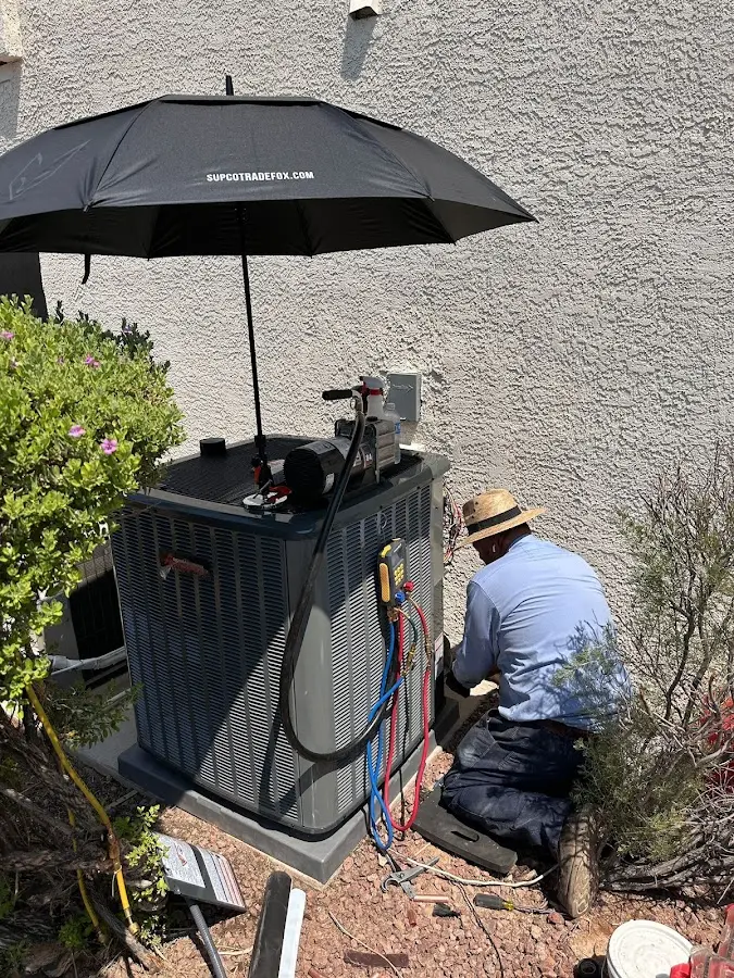 HVAC technician performing outdoor AC maintenance in Pebble Creek