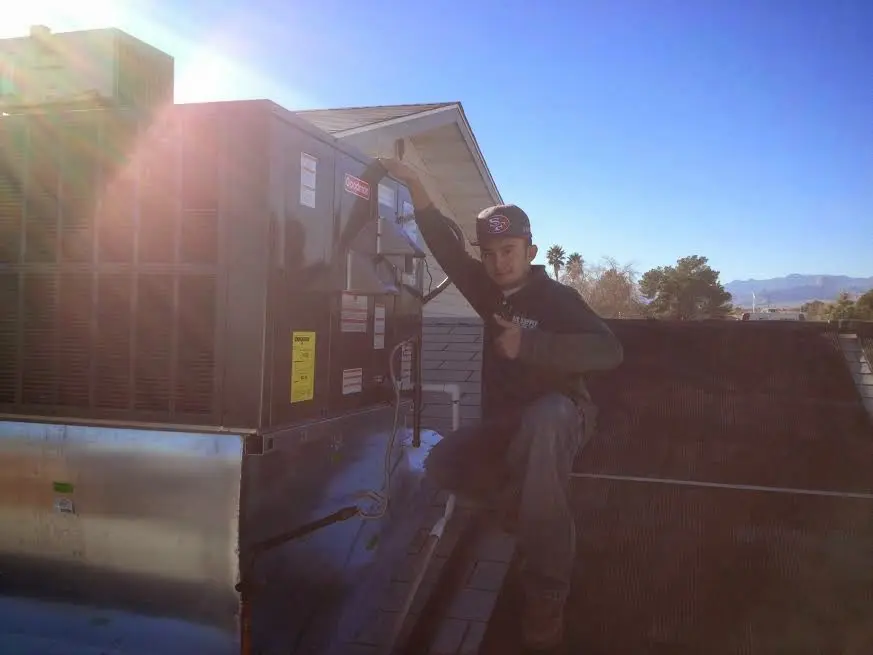 HVAC technician performing Air Duct Cleaning on a rooftop unit in Pebble Creek